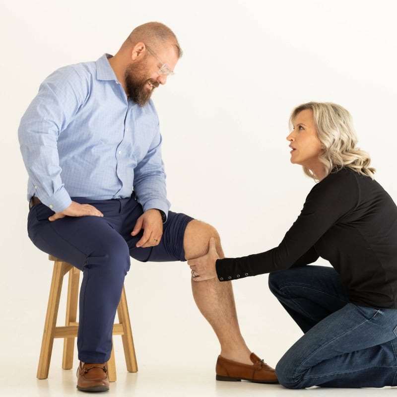 Holistic Healthcare practitioner assessing knee movement during a one-on-one wellness session